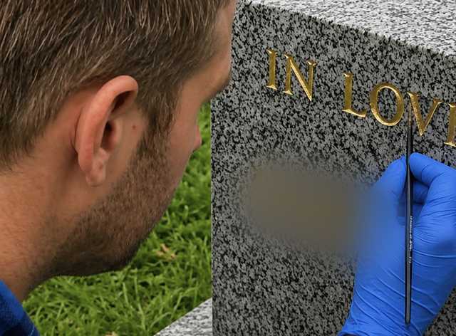 Brush repainting incised letters on a headstone