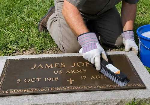 Specialist brushing moss off a granite headstone