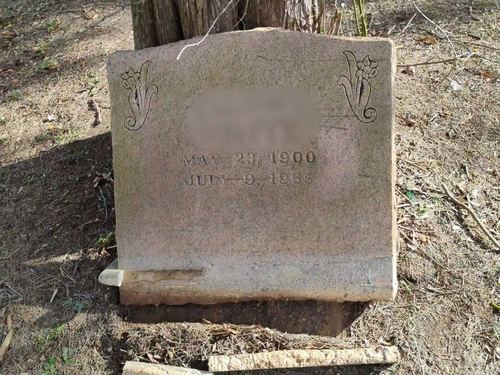 Pink-granite slant headstone before Tending's restoration