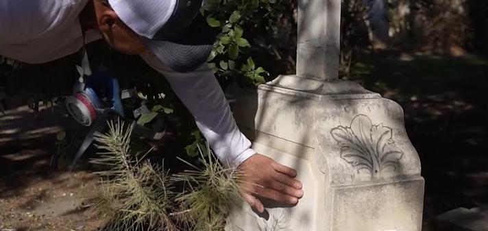 Tending specialist providing careful, eco-friendly care of a marble tombstone as part of our professional promise