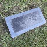Neglected family ledger marker covered in moss before cemetery cleaning in Ohio