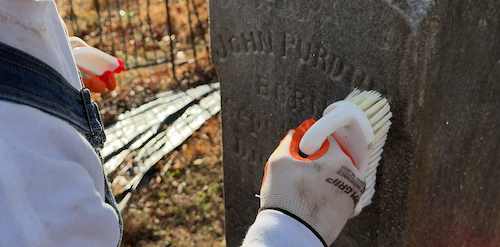 Tending specialist cleaning headstone inscription