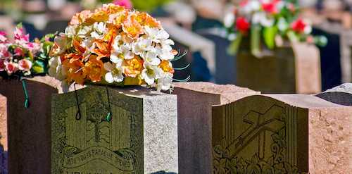 A cemetery headstone featuring intricately carved religious symbols and motifs