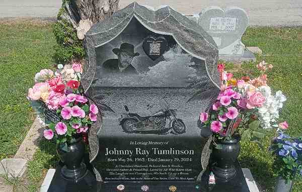 A headstone carving of clasped hands symbolizing love, marriage, and family bonds