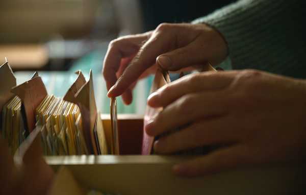 A researcher studying local historical paper records to locate an abandoned family cemetery