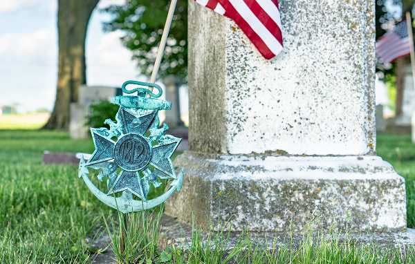 Monument at the military cemetery, flag, and bronze element (ship's anchor and cross)