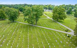 Aerial view of a cemetery in summer with rows of headstones