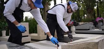 Tending professional specialists renewing the coating on a stone monument