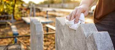 Professional Tending specialist carefully cleaning a headstone using safe, eco-friendly methods